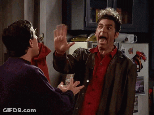 Two Men High Fiving In Front Of Refrigerator GIF