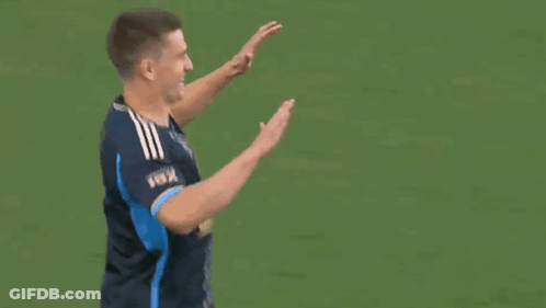 Two Men High Fiving On Field GIF