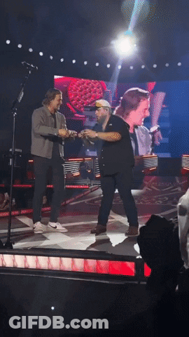 Two Men Holding Hands On Stage GIF