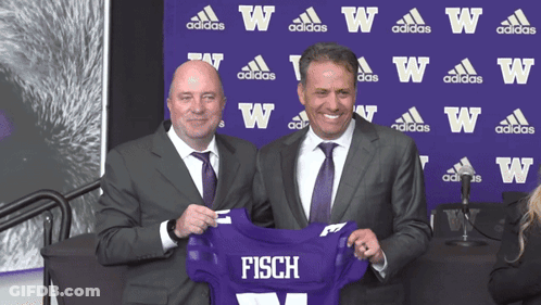 Two Men Holding Purple Jersey Saying Fisch GIF