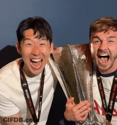 Two Men Holding Trophy One Wearing UEFA Champions League Lanyard GIF