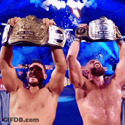 Two Men Holding Wrestling Championship Belts GIF