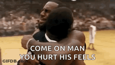 Two Men Hugging Each Other On A Basketball Court . GIF
