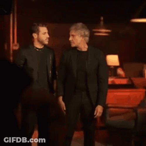 Two Men Hugging In Dark Restaurant GIF