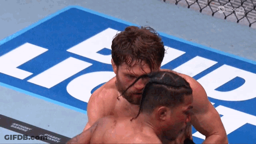 Two Men Hugging In Front Of Bud Light Sign GIF