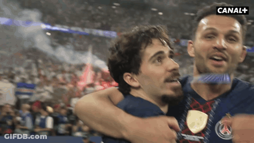 Two Men Hugging In Front Of Canal Sign GIF