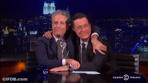 Two Men Hugging In Front Of Comedy Central Logo GIF