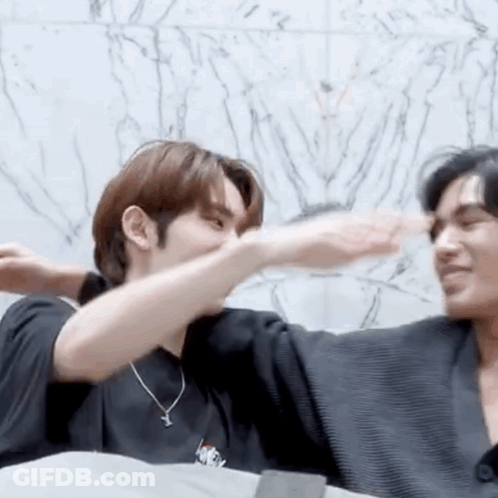 Two Men Hugging In Front Of Marble Wall GIF