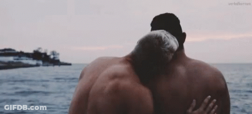 Two Men Hugging In Front Of Ocean With Verberror GIF