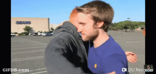 Two Men Hugging In Front Of Sears GIF