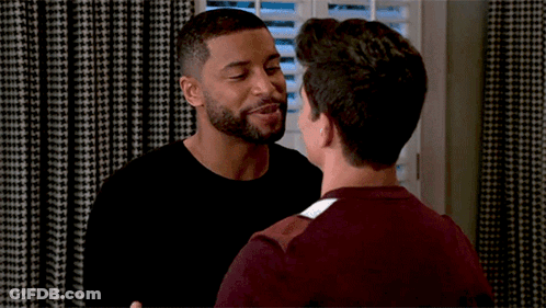 Two Men Hugging In Front Of Shuttered Window GIF