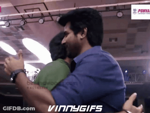 Two Men Hugging In Front Of Vinny Gifs Sign GIF