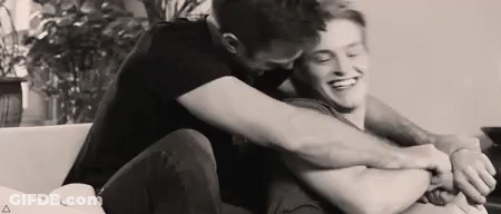 Two Men Hugging On Couch GIF