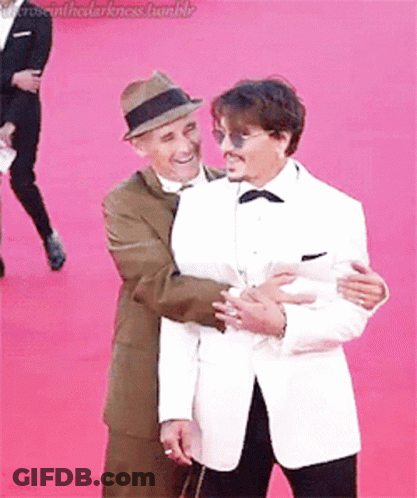 Two Men Hugging On Red Carpet GIF