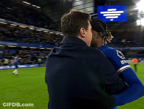 Two Men Hugging On Soccer Field With Everton Sign GIF