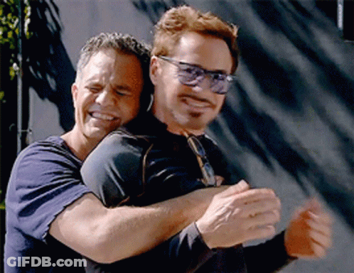 Two Men Hugging, One Wearing Sunglasses GIF