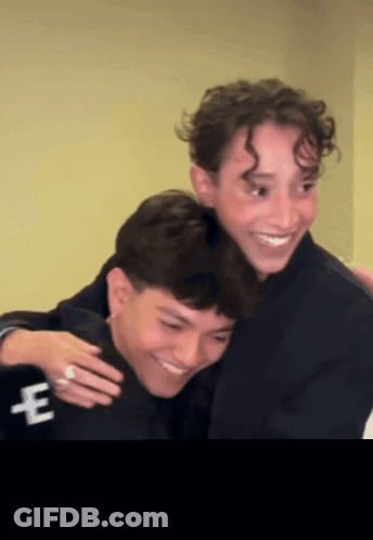Two Men Hugging One With E On Jacket GIF