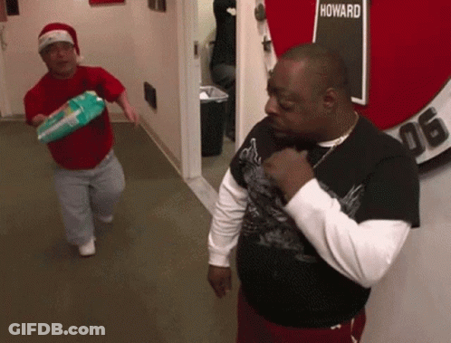 Two Men In A Hallway With A Sign That Says Howard GIF