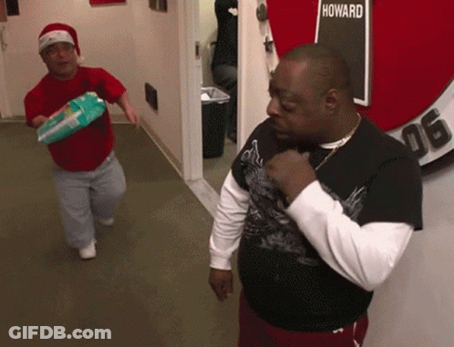 Two Men In A Hallway With A Sign That Says Howard GIF