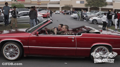 Two Men In A Red Car With The Word Donk Contest On The Bottom Right GIF