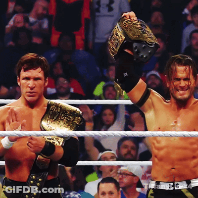Two Men In A Wrestling Ring One Of Whom Is Wearing A Belt That Says ' WWE ' On It GIF