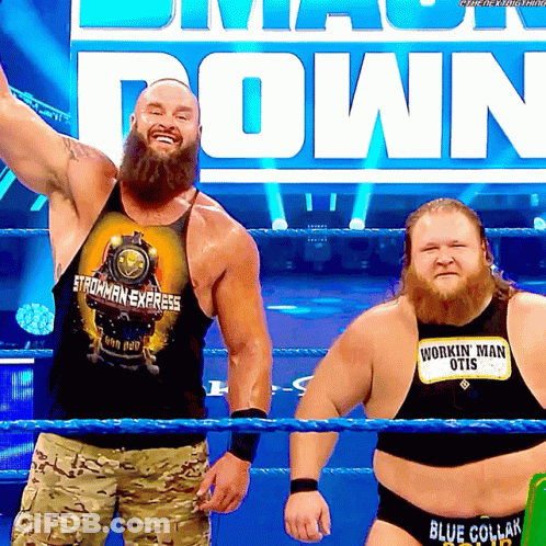 Two Men In A Wrestling Ring One Wearing A Shirt That Says Workin ' Man Otis GIF