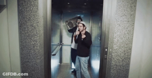 Two Men In An Elevator With One Holding A Boombox On His Shoulder GIF
