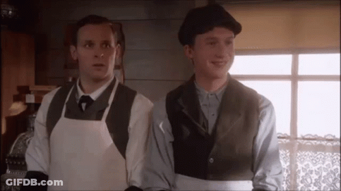 Two Men In Aprons And Hats Standing Together GIF