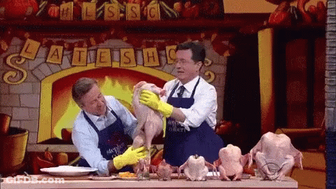 Two Men In Aprons Petting Chicken In Front Of Fireplace Saying Late Show GIF