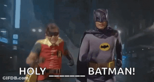 Two Men In Batman Costumes Running Down Street Holding Hands GIF