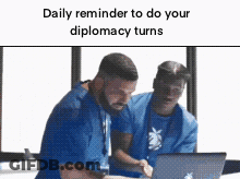 Two Men In Blue Scrubs Looking At Laptop GIF