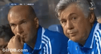 Two Men In Blue Shirts Are Watching A Soccer Game With The Number 3 On The Bottom Of The Screen GIF