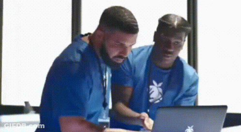 Two Men In Blue Shirts Looking At Laptop GIF
