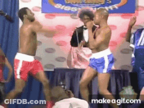 Two Men In Boxing Shorts Are Dancing In Front Of A Sign That Says ' Big ' On It GIF