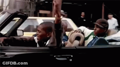 Two Men In Convertible One Giving Middle Finger GIF