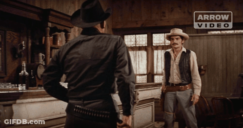 Two Men In Cowboy Hats With Arrow Banner GIF
