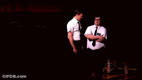 Two Men In Dark Room One With Smith Name Tag GIF