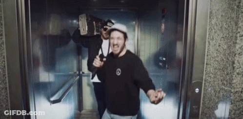 Two Men In Elevator One In Black Mercedes Shirt GIF