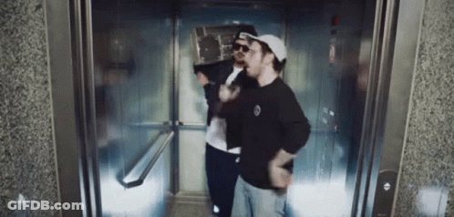 Two Men In Elevator One Wearing Hat And Sunglasses GIF