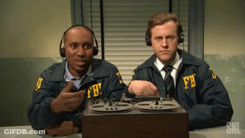 Two Men In Fbi Uniforms Sit At A Desk With A Tape Recorder GIF
