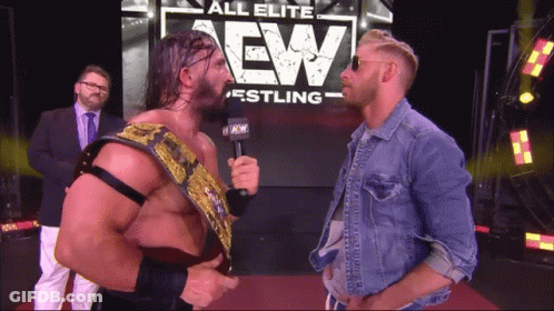 Two Men In Front Of All Elite Wrestling Sign GIF