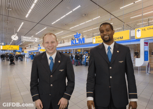 Two Men In Front Of KLM Sign GIF