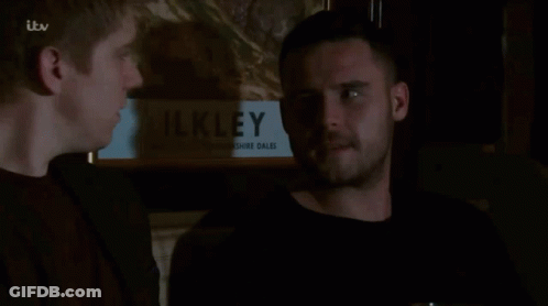 Two Men In Front Of Painting Saying Ilkley GIF