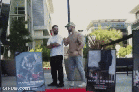 Two Men In Front Of Sign Saying Mark Robin GIF