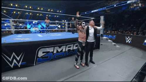 Two Men In Front Of Smackdown Wrestling Ring GIF