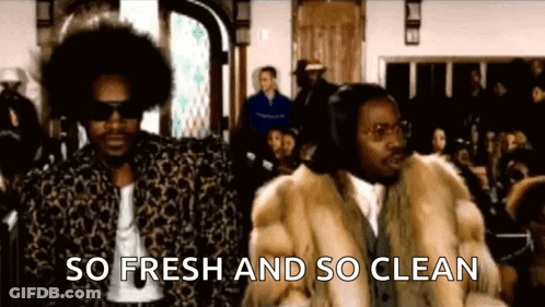 Two Men In Fur Coats Standing Before Crowd GIF