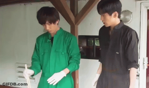 Two Men In Green Jumpsuits And White Gloves Are Standing Next To Each Other . GIF
