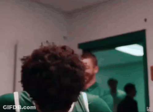 Two Men In Green Shirts Standing Together GIF