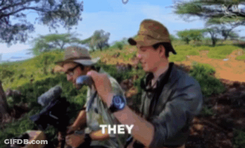 Two Men In Hats And Sunglasses Standing In Field GIF