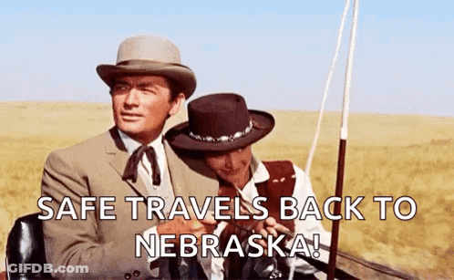 Two Men In Hats Sitting In Field Safe Travels Back To Nebraska GIF